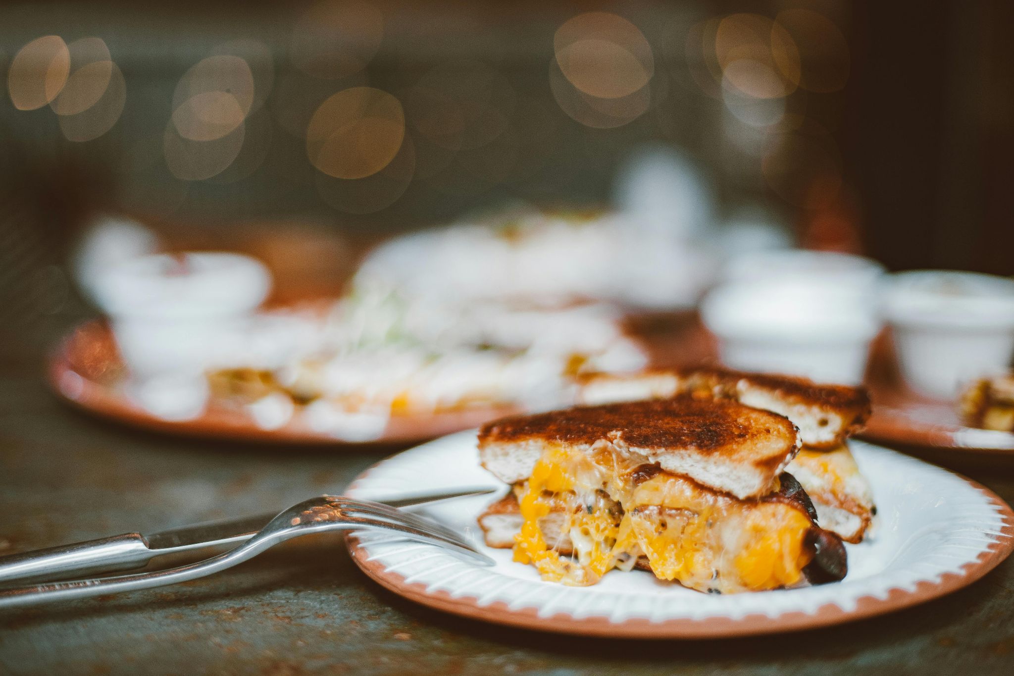 Toasted cheese sandwich on a pink plate.