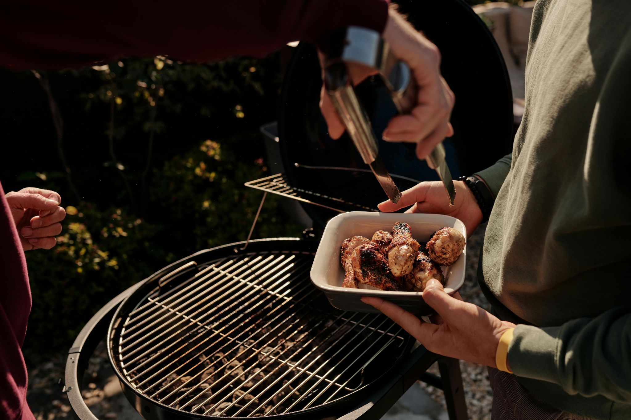 Food being served beside a grill.