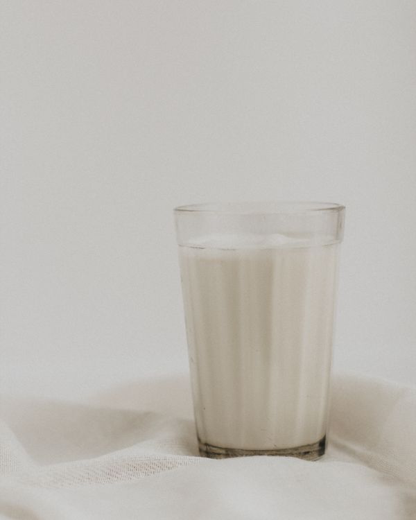 A glass of milk on white cloth.