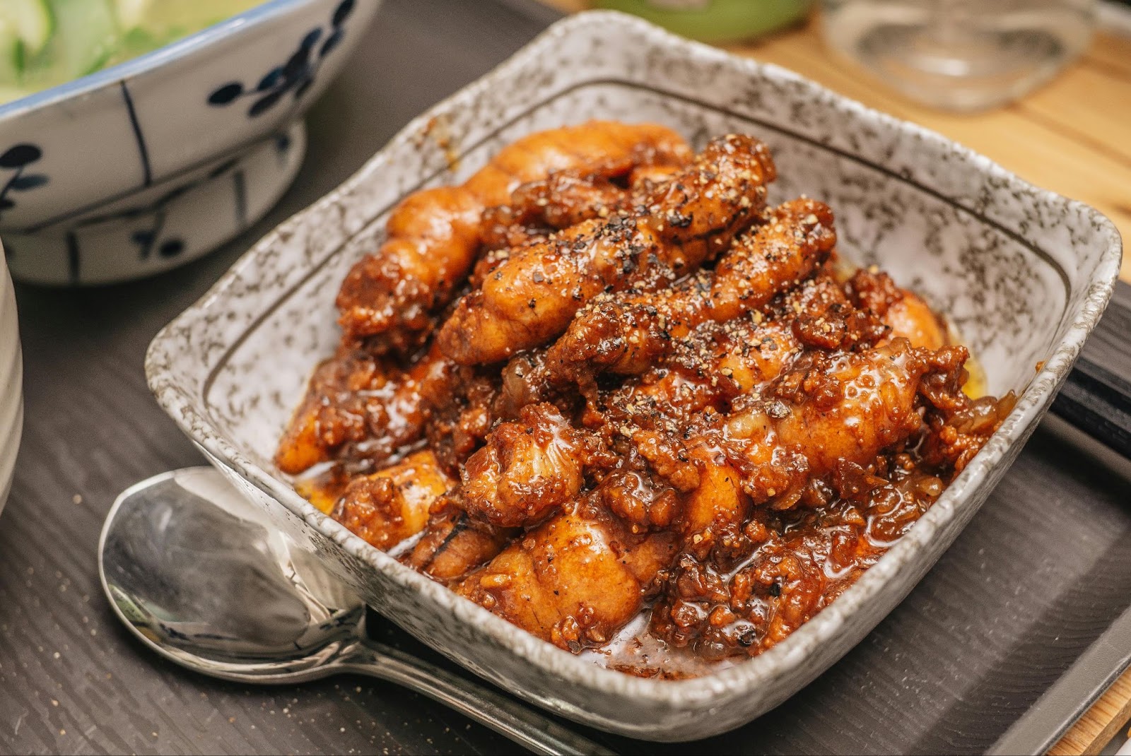 Cooked chicken in sauce in a rectangular ceramic dish.